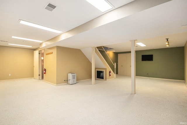 finished basement with visible vents, carpet floors, baseboards, and stairs