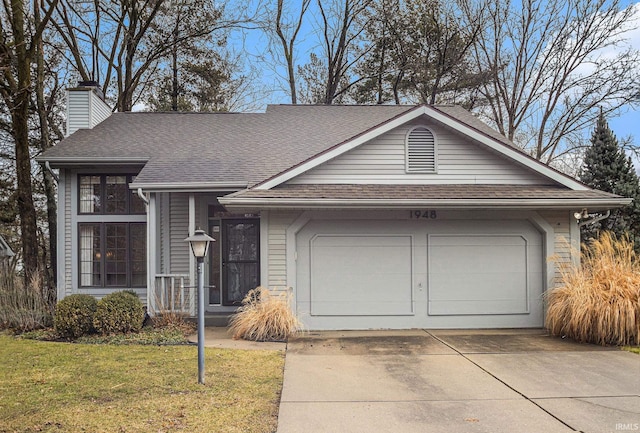 view of front of house with concrete driveway, roof with shingles, a front yard, a chimney, and an attached garage