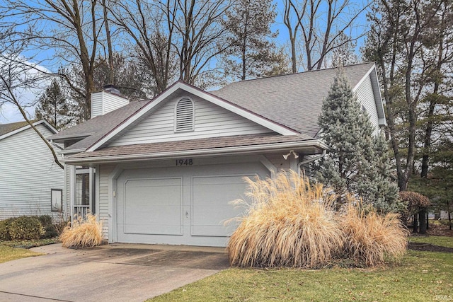 exterior space with a garage, a chimney, driveway, and a shingled roof