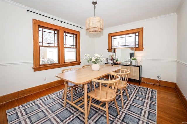 dining space featuring wood finished floors, baseboards, and ornamental molding