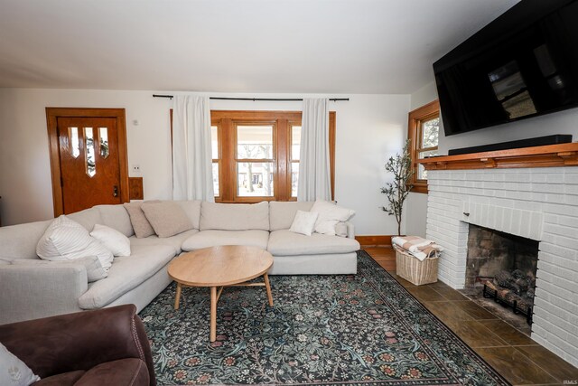 living area with baseboards and a brick fireplace