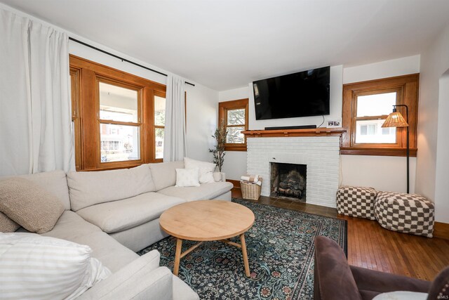 living room featuring a healthy amount of sunlight, a fireplace, and hardwood / wood-style floors