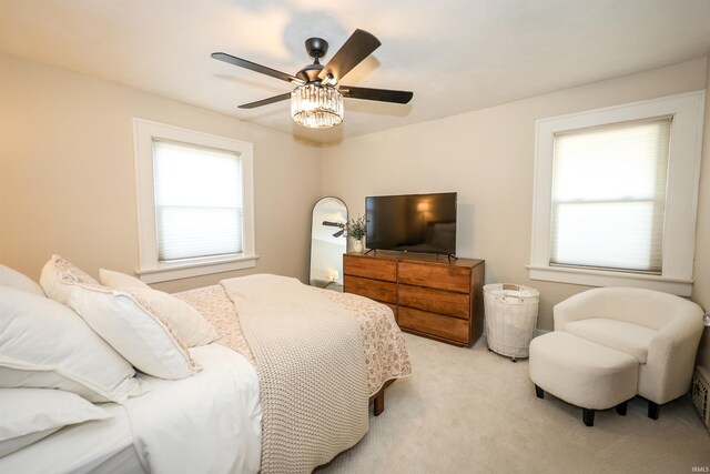 bedroom with light carpet and a ceiling fan