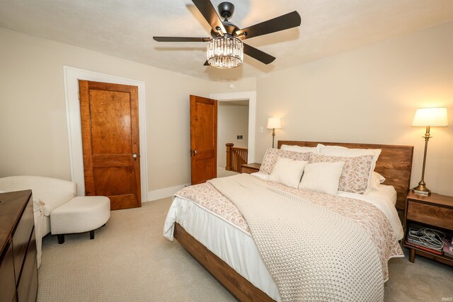 bedroom featuring baseboards, light carpet, and a ceiling fan