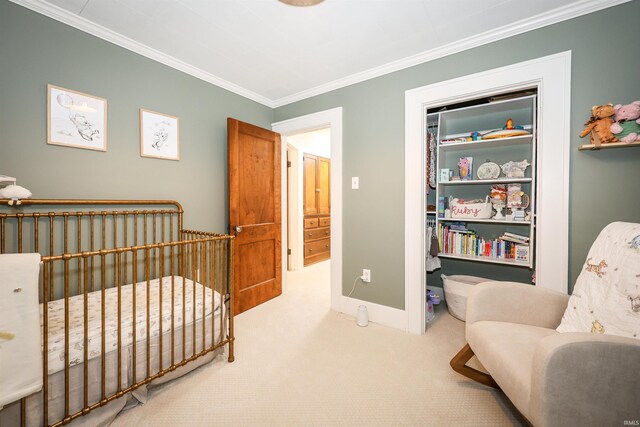 carpeted bedroom featuring crown molding, a nursery area, baseboards, and a closet