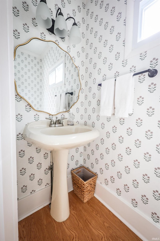 bathroom with wallpapered walls and wood finished floors