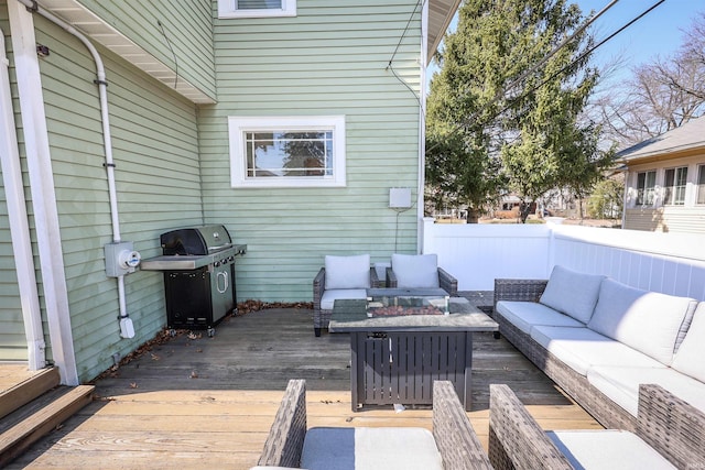 deck with an outdoor living space with a fire pit, area for grilling, and fence