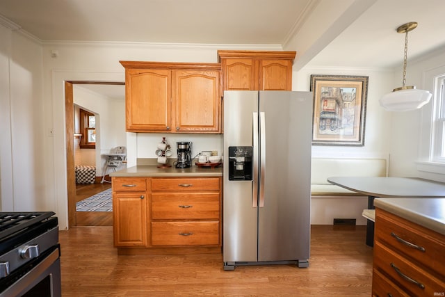 kitchen featuring brown cabinetry, stainless steel appliances, light wood-style floors, and ornamental molding