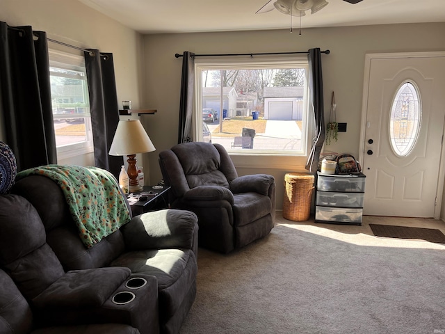 living area with ceiling fan and carpet