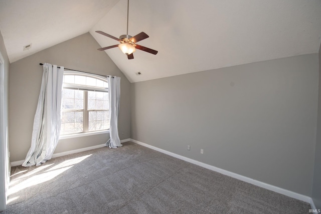 carpeted spare room with visible vents, ceiling fan, baseboards, and vaulted ceiling