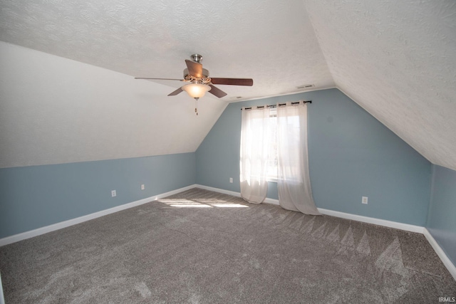 bonus room with visible vents, lofted ceiling, a textured ceiling, carpet floors, and baseboards