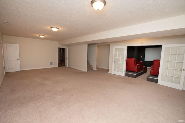 basement featuring visible vents, carpet floors, stairs, and french doors