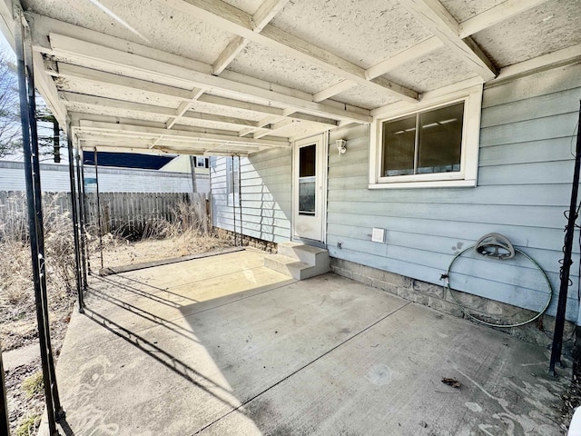 view of patio / terrace featuring a carport, entry steps, and fence