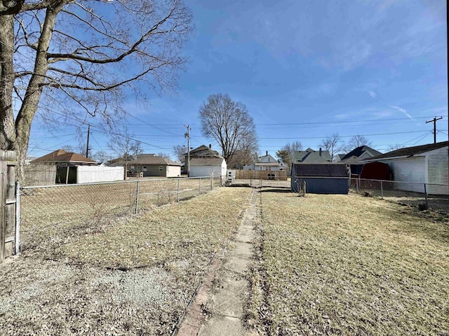 view of yard featuring an outbuilding, a storage unit, and fence