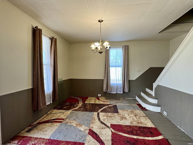 dining room featuring stairs, visible vents, an inviting chandelier, and wainscoting