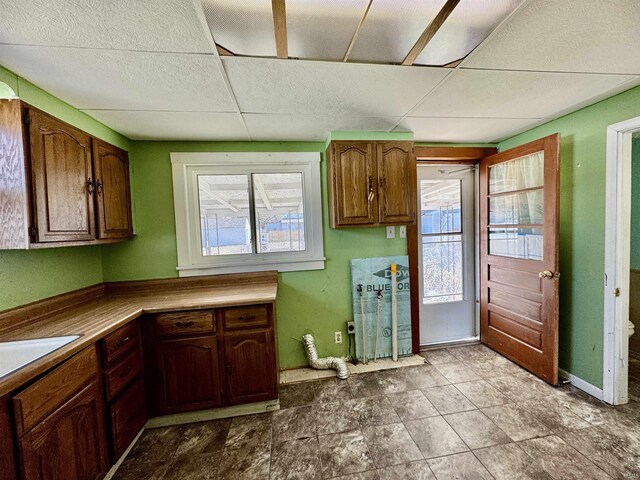 kitchen with baseboards and a drop ceiling