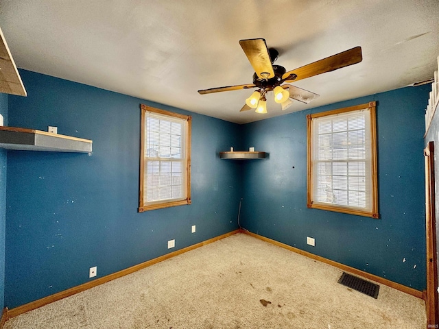 unfurnished room with visible vents, baseboards, a ceiling fan, and carpet flooring