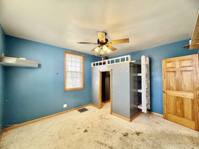 unfurnished bedroom featuring visible vents, baseboards, carpet floors, and a ceiling fan