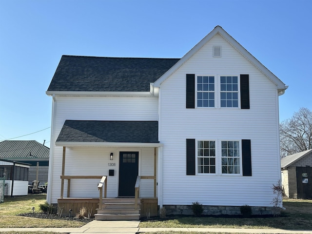 traditional-style house featuring covered porch and roof with shingles