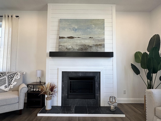 living area featuring dark wood finished floors, baseboards, and a tile fireplace