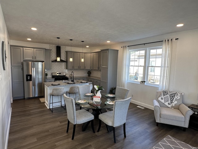 dining room with recessed lighting, baseboards, a textured ceiling, and dark wood finished floors