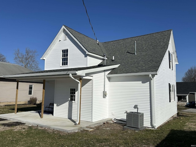 rear view of house featuring central air condition unit, a shingled roof, and a patio