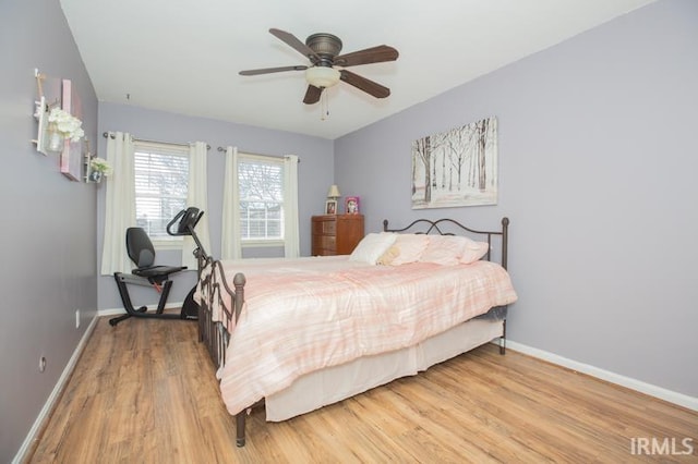 bedroom featuring baseboards, wood finished floors, and a ceiling fan