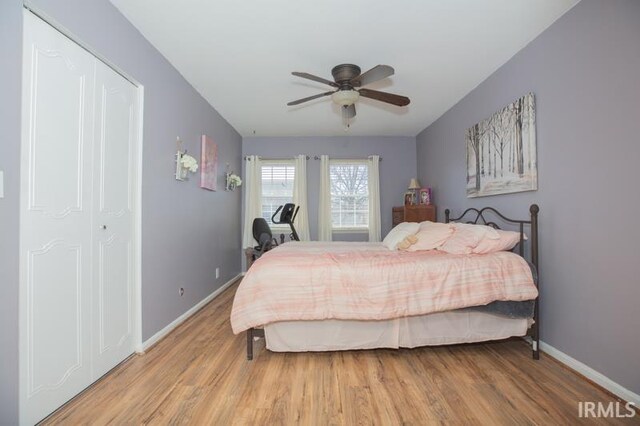 bedroom with ceiling fan, baseboards, and light wood-style floors