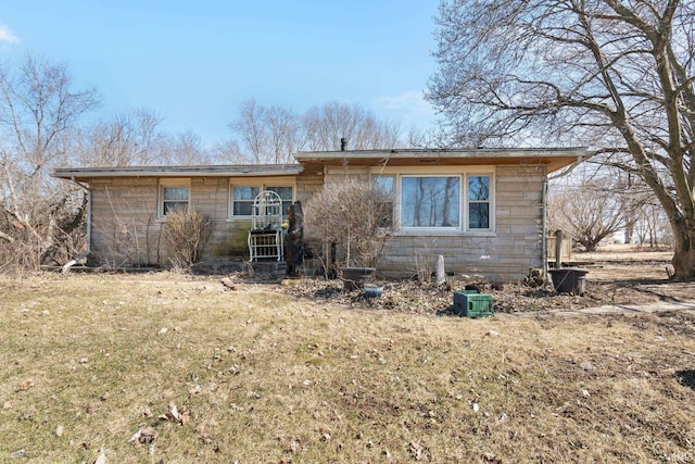 view of front of property with stone siding and a front yard