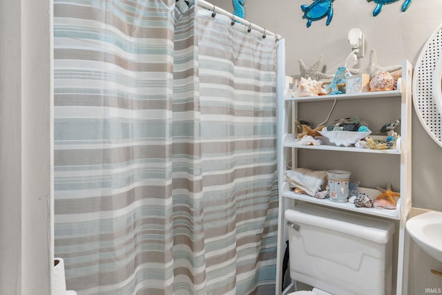 bathroom with toilet and a shower with curtain