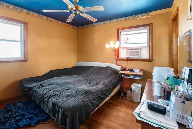 bedroom featuring cooling unit, ceiling fan, and wood finished floors