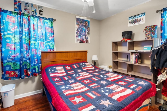 bedroom with a ceiling fan, wood finished floors, and baseboards