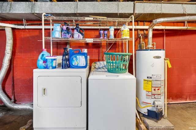 clothes washing area featuring gas water heater, washing machine and dryer, and laundry area