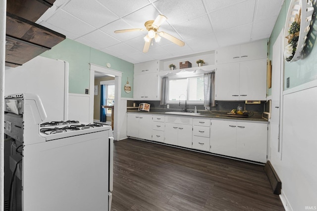 kitchen with gas range, white cabinets, and a sink