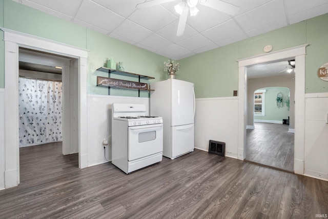 kitchen with visible vents, dark wood finished floors, white appliances, arched walkways, and ceiling fan