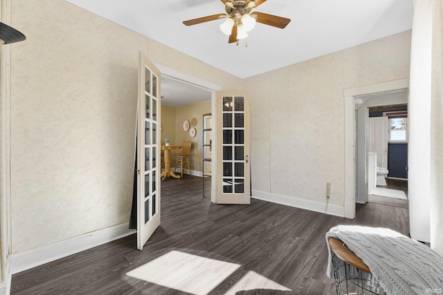 spare room featuring french doors, baseboards, wood finished floors, and a ceiling fan