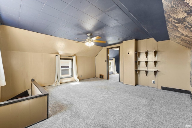 additional living space featuring visible vents, a ceiling fan, lofted ceiling, and carpet floors