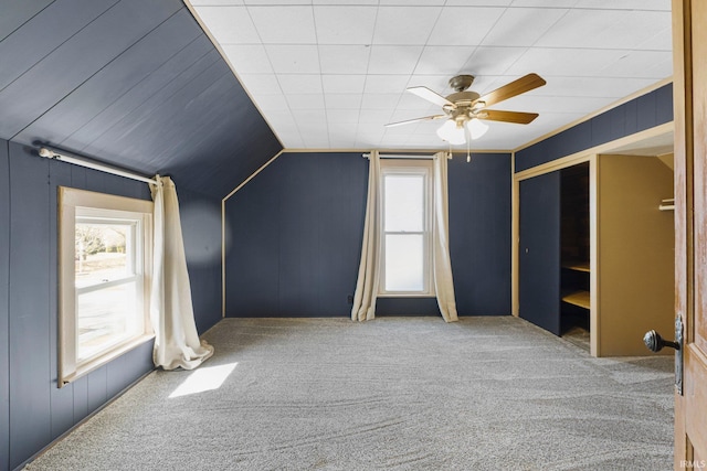 additional living space featuring plenty of natural light, carpet, lofted ceiling, and a ceiling fan