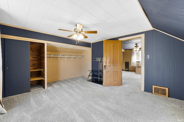 unfurnished bedroom featuring visible vents, a ceiling fan, lofted ceiling, and carpet floors