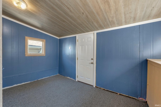 empty room with wooden ceiling and carpet flooring