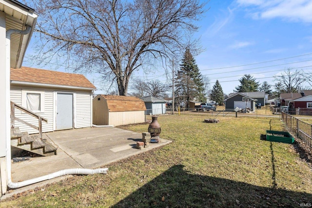 view of yard with a patio, an outbuilding, a shed, and fence