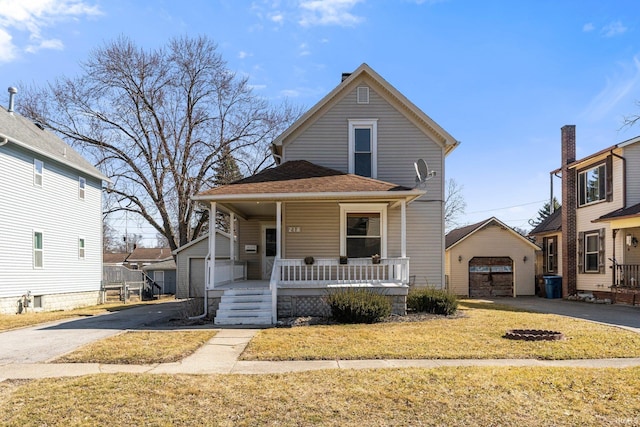 view of front of property featuring driveway, covered porch, an outdoor structure, a front lawn, and a garage