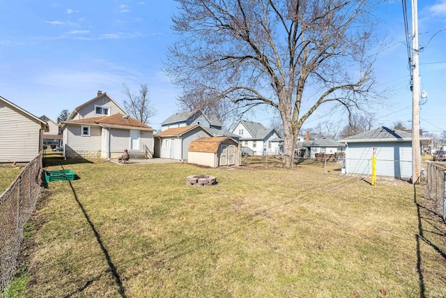 view of yard with an outbuilding, a fenced backyard, and a shed