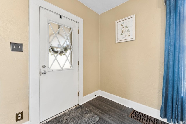 interior space with visible vents, baseboards, and dark wood-style flooring