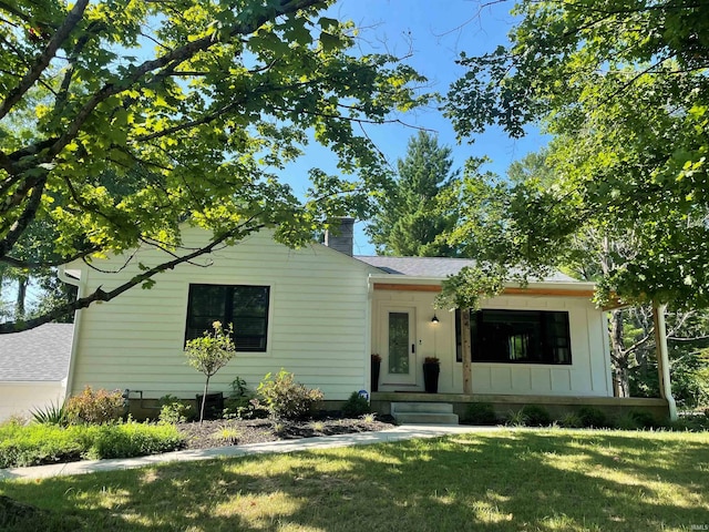 view of front facade with a front lawn and a shingled roof