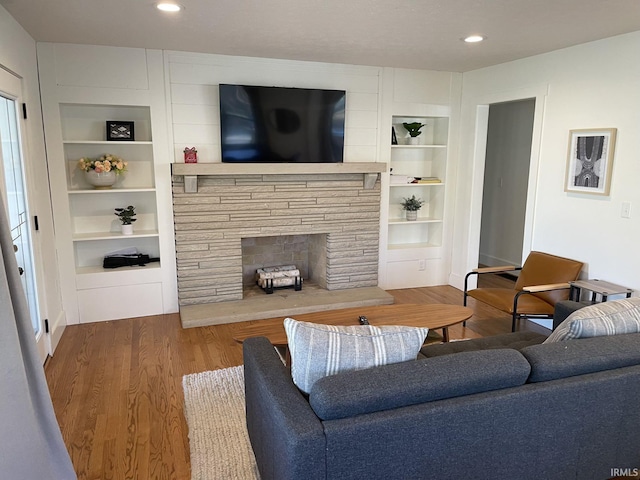 living room with built in features, wood finished floors, and recessed lighting