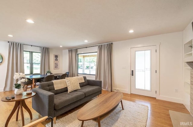 living area featuring light wood finished floors, visible vents, recessed lighting, and baseboards