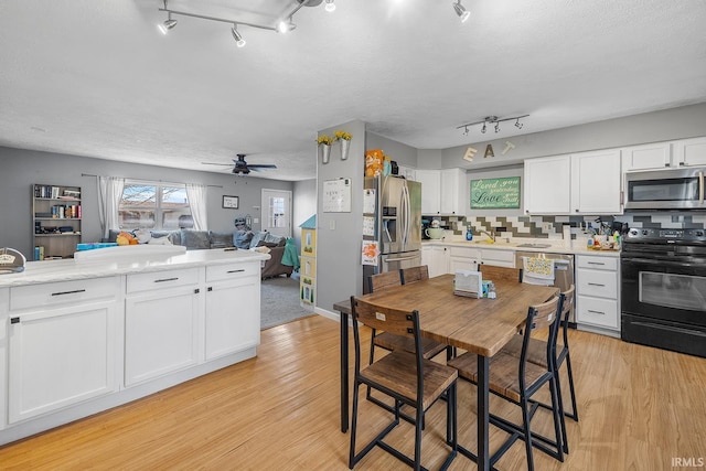 kitchen with light countertops, white cabinets, tasteful backsplash, and appliances with stainless steel finishes