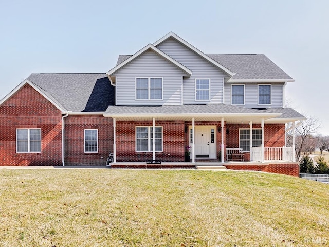 view of front of house featuring brick siding, roof with shingles, and a front lawn