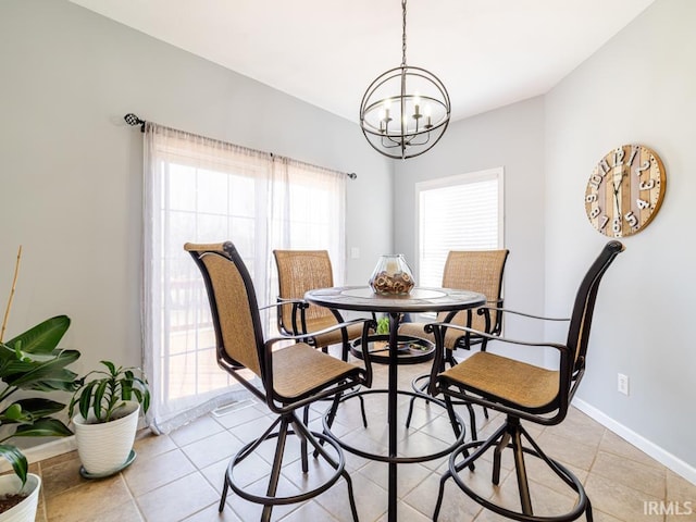 dining room featuring light tile patterned floors, baseboards, and a chandelier